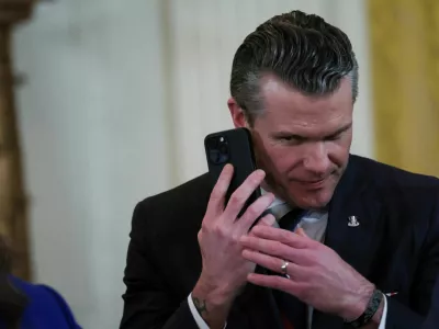 FILE PHOTO: U.S. Defense Secretary Pete Hegseth uses a phone as he attends a joint press conference of U.S. President Donald Trump and Israeli Prime Minister Benjamin Netanyahu in the East Room at the White House in Washington, U.S., February 4, 2025. REUTERS/Leah Millis/File Photo