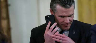 FILE PHOTO: U.S. Defense Secretary Pete Hegseth uses a phone as he attends a joint press conference of U.S. President Donald Trump and Israeli Prime Minister Benjamin Netanyahu in the East Room at the White House in Washington, U.S., February 4, 2025. REUTERS/Leah Millis/File Photo