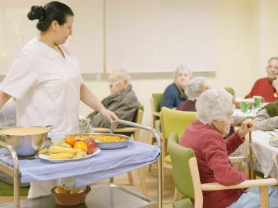Female cook entering with food to the dining room of geriatric / Foto: Ramon Ivan Moreno Prieto