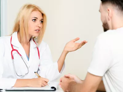 Woman doctor is talking to male patient in hospital office. Healthcare and medical service. / Foto: Nanostockk