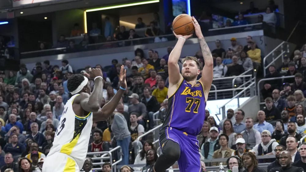 Los Angeles Lakers guard Luka Doncic (77) shoots in front of Indiana Pacers forward Pascal Siakam (43) during the first half of an NBA basketball game in Indianapolis, Wednesday, March 26, 2025. (AP Photo/AJ Mast)