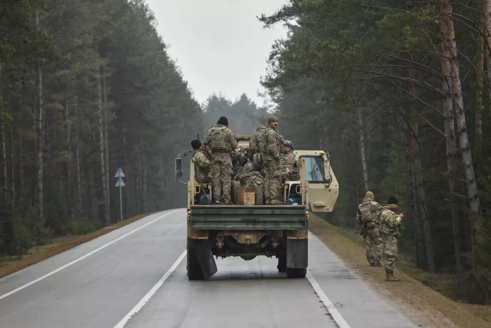 U.S. soldiers stand in the back of a truck on a road towards a training range in Pabrade, north of the capital Vilnius, Lithuania on Thursday, March 27, 2025. (AP Photo/Mindaugas Kulbis)