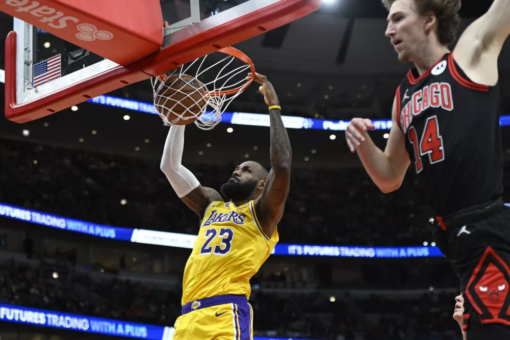 Los Angeles Lakers' LeBron James dunks during the first half of an NBA basketball game against the Chicago Bulls Thursday, March 27, 2025, in Chicago. (AP Photo/Paul Beaty)