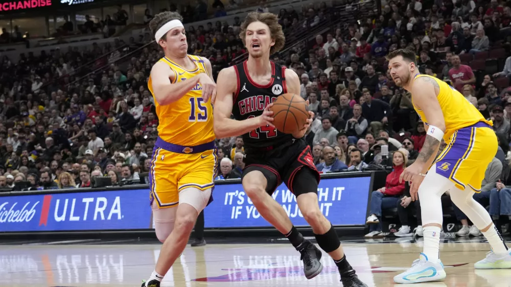 Mar 27, 2025; Chicago, Illinois, USA; Los Angeles Lakers guard Austin Reaves (15) defends Chicago Bulls forward Matas Buzelis (14) during the first quarter at United Center. Mandatory Credit: David Banks-Imagn Images