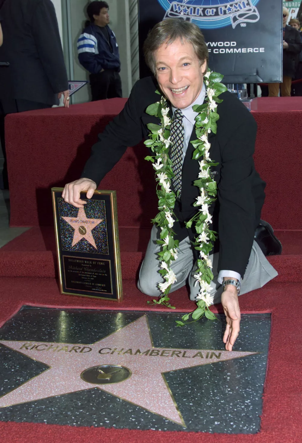 FILE PHOTO: Actor Richard Chamberlain poses with his newly unveiled star on the Hollywood Walk of Fame during ceremonies honoring Chamberlain February 29 in Hollywood. Chamberlain, best know for his role in the 1960's television drama series " Dr. Kildare" is currently starring in the national Broadway tour production of " The Sound of Music. REUTERS/Rose Prouser/File Photo
