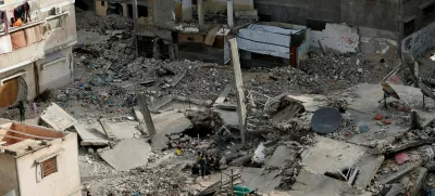 FILE PHOTO: A Palestinian woman walks near the rubble of houses, in Khan Younis in the southern Gaza Strip March 29, 2025. REUTERS/Hatem Khaled/File Photo