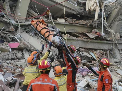 In this photo released by Xinhua News Agency, members of a China search and rescue team transfer a pregnant survivor from a collapsed building in the aftermath of an earthquake in Mandalay, Myanmar, Monday, March 31, 2025. (Myo Kyaw Soe/Xinhua via AP)