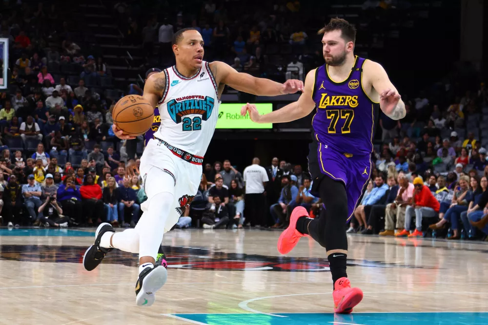 Mar 29, 2025; Memphis, Tennessee, USA; Memphis Grizzlies guard Desmond Bane (22) drives to the basket as Los Angeles Lakers guard Luka Doncic (77) defends during the fourth quarter at FedExForum. Mandatory Credit: Petre Thomas-Imagn Images