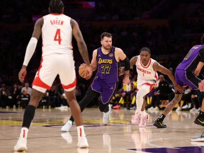 Mar 31, 2025; Los Angeles, California, USA; Los Angeles Lakers guard Luka Doncic (77) dribbles the ball against Houston Rockets forward Amen Thompson (1) during the first half at Crypto.com Arena. Mandatory Credit: Kiyoshi Mio-Imagn Images