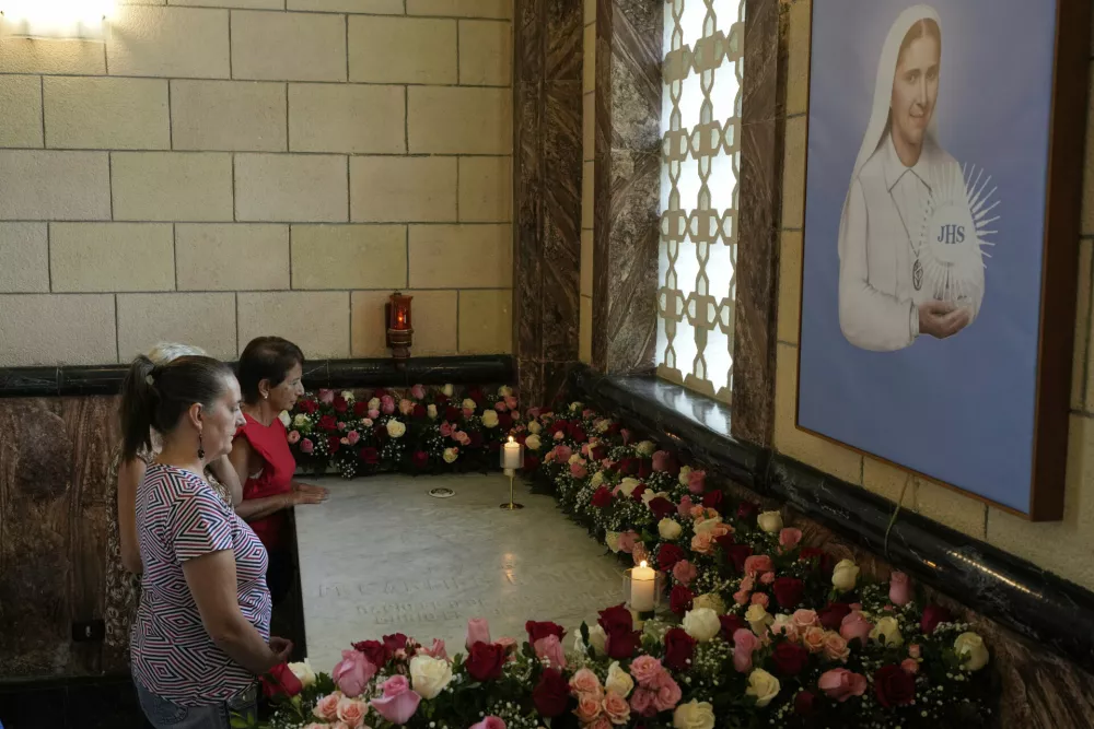 Believer pray next to the tomb with remains of Blessed Maria Carmen Rendiles at the Belen's school church in Caracas, Venezuela, Monday, March 31, 2025. (AP Photo/Ariana Cubillos)