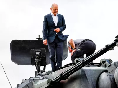 FILE PHOTO: German Chancellor Olaf Scholz climbs on a German self-propelled anti-aircraft gun Flakpanzer Gepard with head of training at arms manufacturer Krauss-Maffei Juergen Schoch, during a visit of the training program for Ukrainian soldiers on the Gepard anti-aircraft tank in Putlos near Oldenburg, Germany August 25, 2022. Axel Heimken/Pool via REUTERS/File Photo