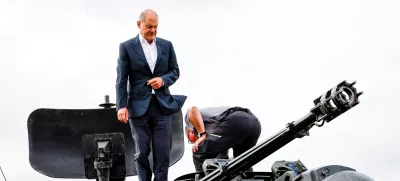 FILE PHOTO: German Chancellor Olaf Scholz climbs on a German self-propelled anti-aircraft gun Flakpanzer Gepard with head of training at arms manufacturer Krauss-Maffei Juergen Schoch, during a visit of the training program for Ukrainian soldiers on the Gepard anti-aircraft tank in Putlos near Oldenburg, Germany August 25, 2022. Axel Heimken/Pool via REUTERS/File Photo