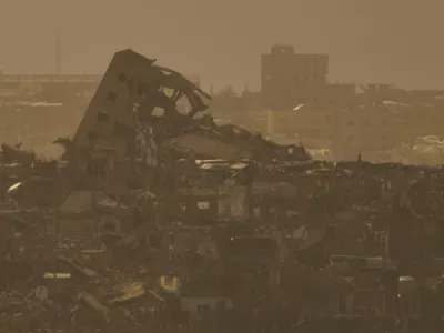 Buildings that were destroyed during the Israeli ground and air operations stand in northern of Gaza Strip as seen from southern Israel, Tuesday, April 1, 2025. (AP Photo/Leo Correa)