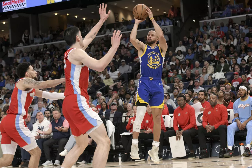 Golden State Warriors guard Stephen Curry (30) shoots against Memphis Grizzlies center Zach Edey, center, and guard Scotty Pippen Jr., left, in the first half of an NBA basketball game, Tuesday, April 1, 2025, in Memphis, Tenn. (AP Photo/Brandon Dill)