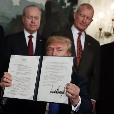 President Donald Trump displays signs a presidential memorandum imposing tariffs and investment restrictions on China in the Diplomatic Reception Room of the White House, Thursday, March 22, 2018, in Washington. (AP Photo/Evan Vucci)