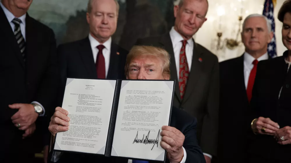 President Donald Trump displays signs a presidential memorandum imposing tariffs and investment restrictions on China in the Diplomatic Reception Room of the White House, Thursday, March 22, 2018, in Washington. (AP Photo/Evan Vucci)