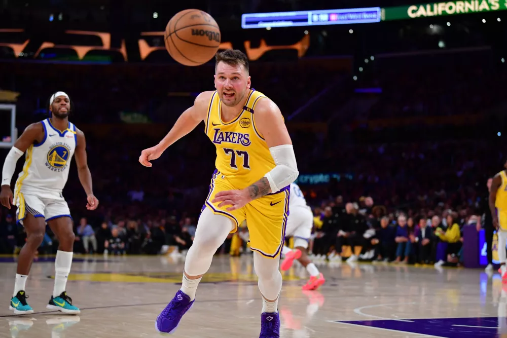 Apr 3, 2025; Los Angeles, California, USA; Los Angeles Lakers guard Luka Doncic (77) plays for the ball against the Golden State Warriors during the second half at Crypto.com Arena. Mandatory Credit: Gary A. Vasquez-Imagn Images