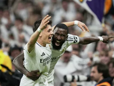 Real Madrid's Arda Guler, left, and Real Madrid's Antonio Rudiger celebrate after a fourth goal in extra time during the Spanish Copa del Rey semifinal second leg soccer match between Real Madrid and and Real Sociedad in Madrid, Spain Tuesday, April 1, 2025. (AP Photo/Bernat Armangue)