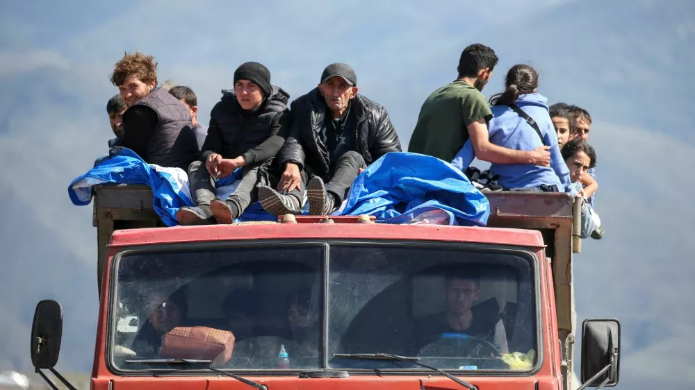 FILE PHOTO: Refugees from Nagorno-Karabakh region ride in a truck upon their arrival at the border village of Kornidzor, Armenia, September 27, 2023. REUTERS/Irakli Gedenidze   TPX IMAGES OF THE DAY/File Photo