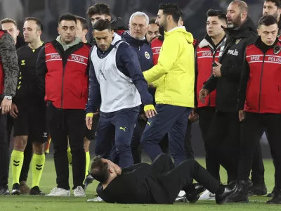 Galatasaray's coach Okan Buruk, bottom, lies on the ground after Fenerbahce's manager Jose Mourinho, center, grabbed his nose at the end of the Turkish Cup quarterfinals soccer match between Fenerbahce and Galatasaray at the Ulker stadium, in Istanbul, Wednesday, April 2, 2025. (Murat Akbas/Dia Photo via AP)