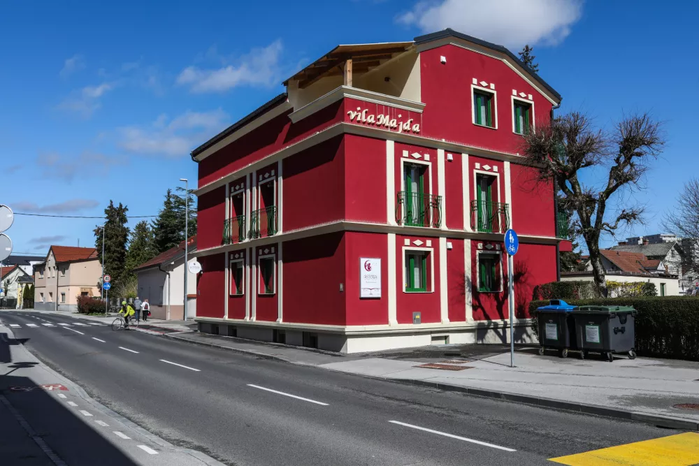 Velika prenovljena bordo rdeča hi&scaron;a, s katere poleg barve skače &scaron;e napis Vila Majda. Hotel ogla&scaron;ujejo, da se nahaja v me&scaron;čanski vili.