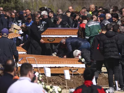 A man cries leaning on a coffin during the funeral ceremony of the victims of a massive nightclub fire in the town of Kocani, North Macedonia, Thursday, March 20, 2025. (AP Photo/Armin Durgut)