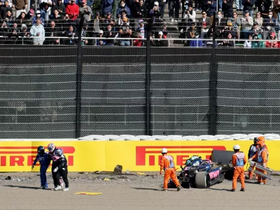 Formula One F1 - Japanese Grand Prix - Suzuka Circuit, Suzuka, Japan - April 4, 2025 Alpine's Jack Doohan walks away with a medical team as marshals attend his car after the crashing during practice REUTERS/Issei Kato