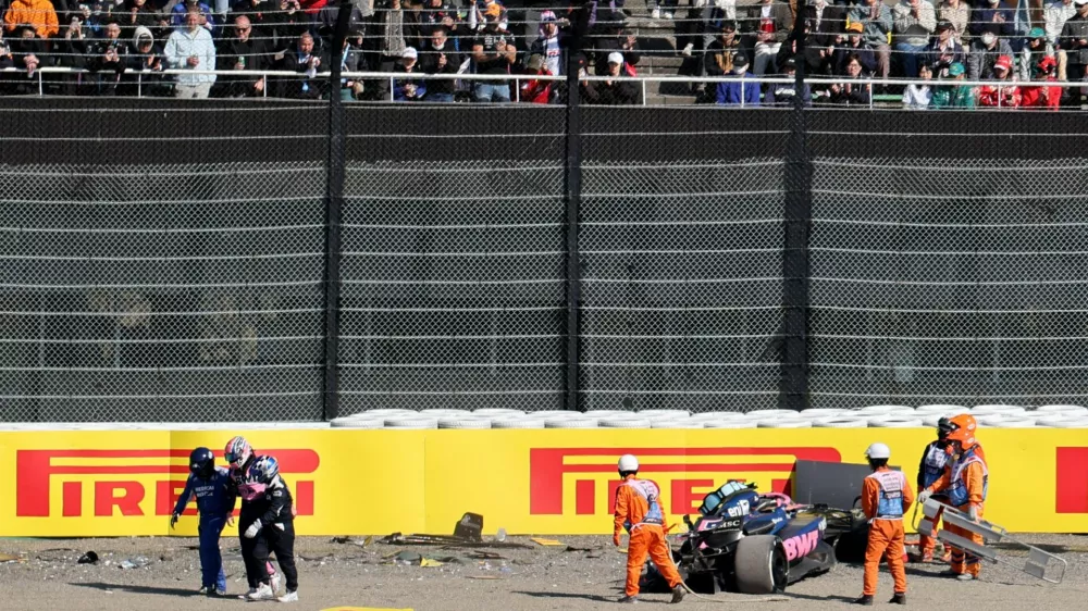 Formula One F1 - Japanese Grand Prix - Suzuka Circuit, Suzuka, Japan - April 4, 2025 Alpine's Jack Doohan walks away with a medical team as marshals attend his car after the crashing during practice REUTERS/Issei Kato