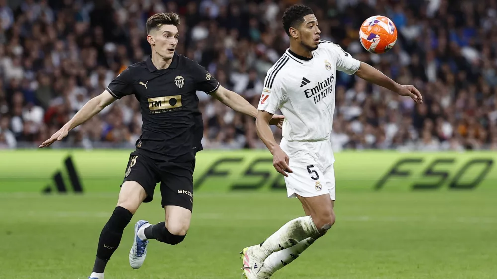 Soccer Football - LaLiga - Real Madrid v Valencia - Santiago Bernabeu, Madrid, Spain - April 5, 2025 Real Madrid's Jude Bellingham in action with Valencia's Pepelu REUTERS/Juan Medina