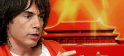 French musician Jean-Michel Jarre speaks about his upcoming concert in front of a picture of the Forbidden City at a press conference in Beijing Saturday, Oct. 9, 2004. Jarre will perform to an expected audience of 50,000, including French President Jacques Chirac at the Forbidden City and Tiananmen Square in Beijing Sunday. (AP Photo/Str)