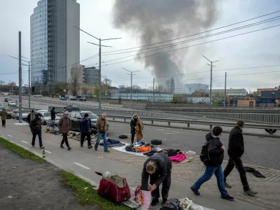 Vendors put their wares on display at a flea market as smoke rises from a nearby site of a Russian missile strike, amid Russia's attack on Ukraine, in Kyiv, Ukraine, April 6, 2025. REUTERS/Thomas Peter     TPX IMAGES OF THE DAY