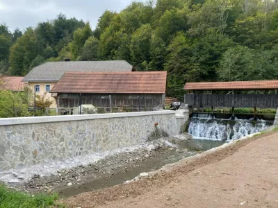 Nadvi&scaron;an in obložen zid nad mostom z obnovljenim prelivom. Polhov Gradec / Foto: Gradascica.si