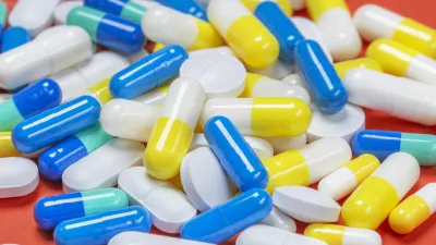 Colored pills, pills and capsules on a red background / Foto: Okskaz