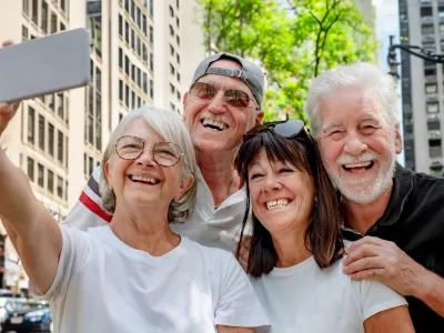 A cheerful group of senior retired friends visiting New York City take a selfie on the street. Two couples of travelers on a leisure vacation enjoy the journey and freedom / Foto: Lucigerma