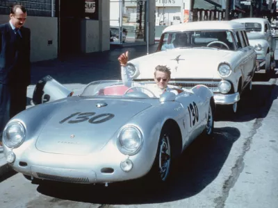 James Dean waves from behind the wheel of his Porsche 550 Spyder 'Little Bastard' numbered 130 (VIN 550-0055) parked on Vine Street in Los Angeles, California, USA. (Photo by Bettmann via Getty Images) / Foto: Bettmann