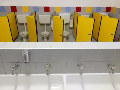 long sink with four taps inside a kindergarten with toilets with yellow doors without children / Foto: Chiccododifc