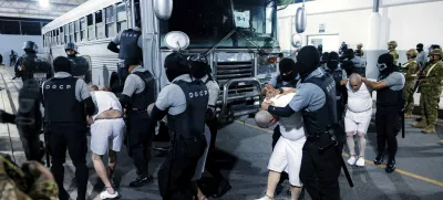 In this photo provided by El Salvador's presidential press office guards transfer deportees from the U.S to the Terrorism Confinement Center in Tecoluca, El Salvador, Monday, March 31, 2025. (El Salvador presidential press office via AP)