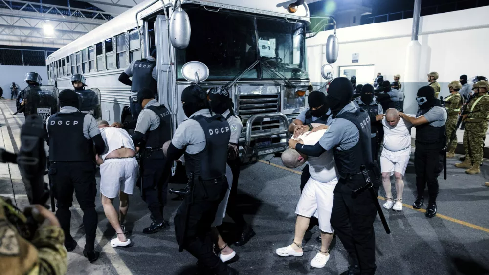 In this photo provided by El Salvador's presidential press office guards transfer deportees from the U.S to the Terrorism Confinement Center in Tecoluca, El Salvador, Monday, March 31, 2025. (El Salvador presidential press office via AP)