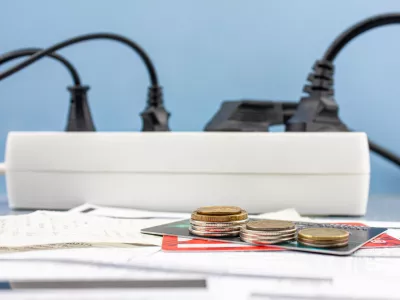 The Money, bank credit cards and electricity bills on the background of an electrical outlet. Electricity debts, the concept of rising electricity prices. / Foto: Bin Kontan