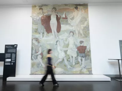07 April 2025, Dresden: A woman walks in front of an early work by Gerhard Richter during a press conference at the Hygiene Museum (DHMD). The mural "Lebensfreude" in the museum's foyer was created in 1956 as Gerhard Richter's graduation work and was painted over in 1979. After a long restoration, the painting has been partially unveiled in Dresden for the first time in over 40 years. Photo: Sebastian Kahnert/dpa - ACHTUNG: Nur zur redaktionellen Verwendung im Zusammenhang mit der aktuellen Berichterstattung