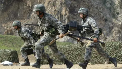 Members of People's Liberation Army (PLA) coastal defence force carry a machine gun during a drill to mark the upcoming 87th Army Day at a military base in Qingdao, Shandong province July 29, 2014. The PLA Army Day falls on August 1 every year. Chinese President Xi Jinping has pledged to strike hard against graft in the military, urging soldiers to banish corrupt practices and ensure their loyalty to the ruling Communist Party, state media reported on Friday. Picture taken July 29, 2014. REUTERS/Stringer (CHINA - Tags: MILITARY POLITICS ANNIVERSARY) CHINA OUT. NO COMMERCIAL OR EDITORIAL SALES IN CHINA