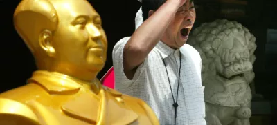 A Chinese tourist yawns as he walks past a bust of Mao Zedong and a stone lion along a commercial district in Beijing, China, Sunday, June 29, 2003. Domestic tourism is trickling back into the Chinese capital after the WHO travel advisory was lifted. The city's tourist industry - which accounts for about one-third of its economic output - lost an estimated 45 billion yuan (US.4 billion) in tourism dollars due to the SARS epidemic as domestic and foreign tourists kept away. (AP Photo/Ng Han Guan)