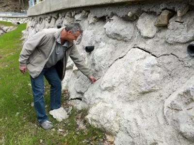 Boris &Scaron;tupar pokaže na vidne razpoke, ki jih je na povsem novi &scaron;karpi naredila teža tovornjakov, svoje pa je dodala &scaron;e voda. Foto: Tomaž Skale