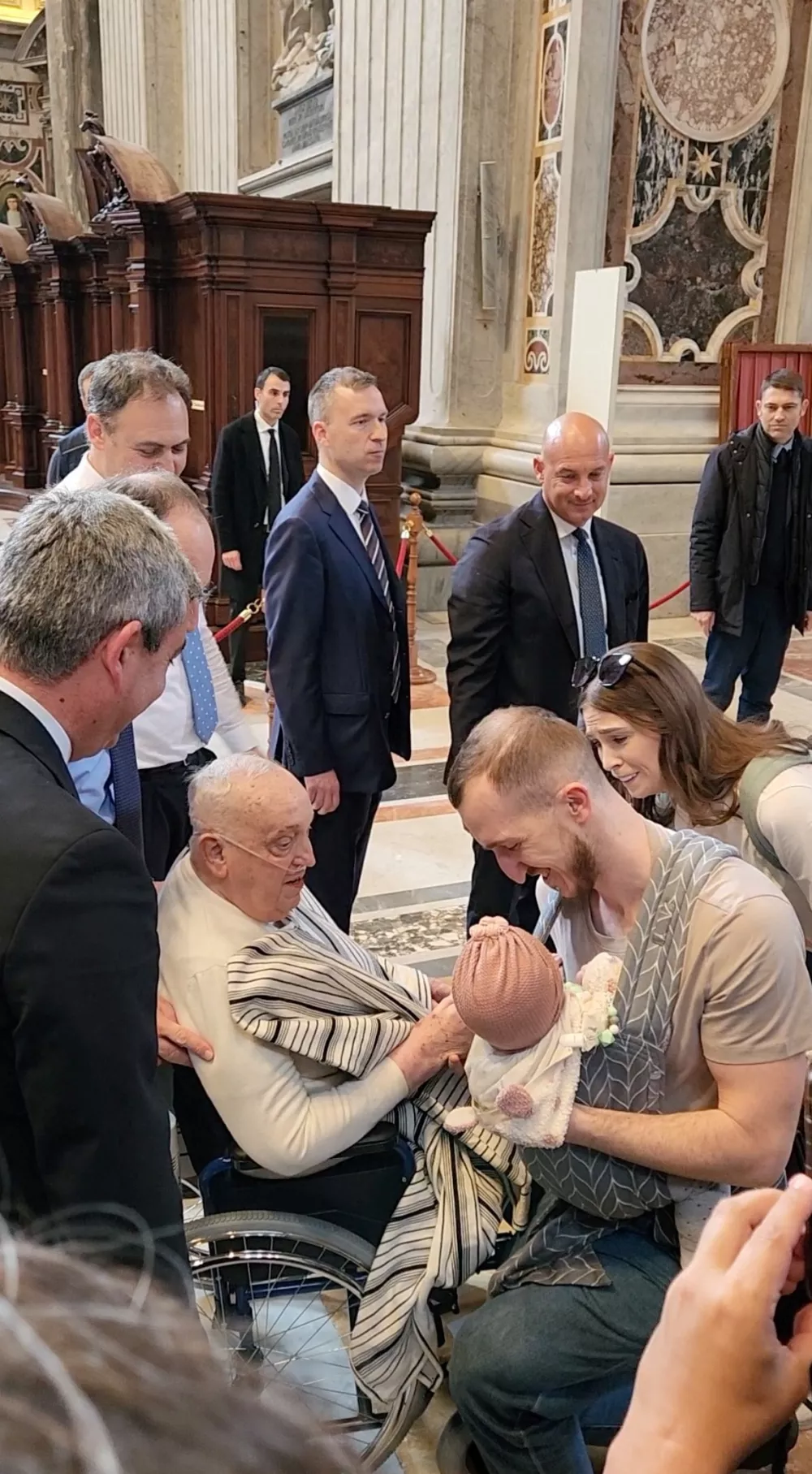 Pope Francis blesses a baby as he makes a surprise visit to St. Peter's Basilica on wheelchair, at the Vatican, April 10, 2025 in this screengrab taken from a handout video. Luiz Gil /Handout via REUTERS  THIS IMAGE HAS BEEN SUPPLIED BY A THIRD PARTY. MANDATORY CREDIT.