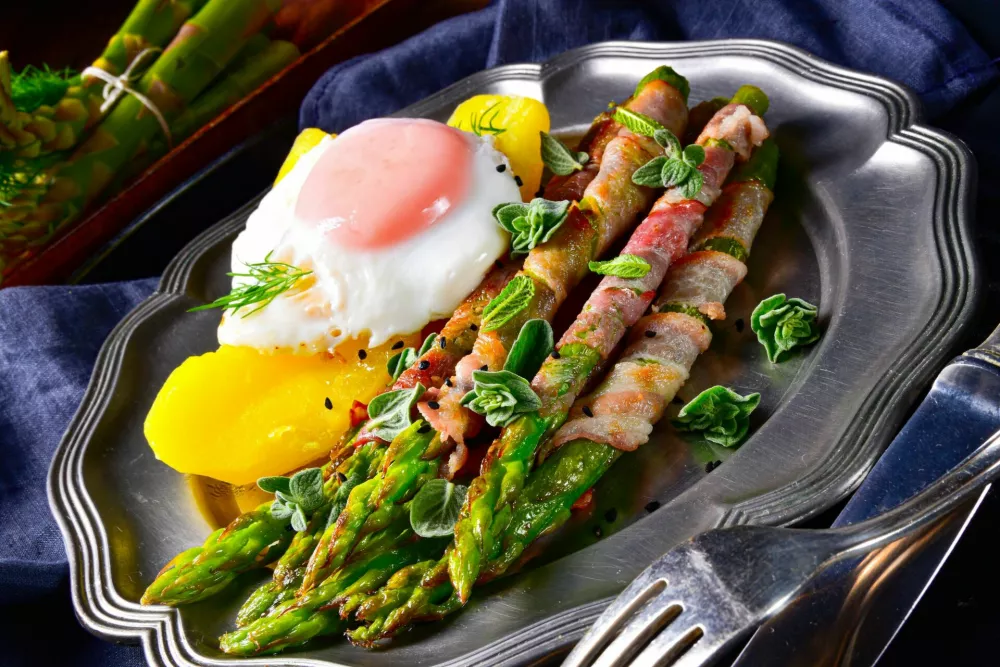 delicious green asparagus wrapped in bacon and egg