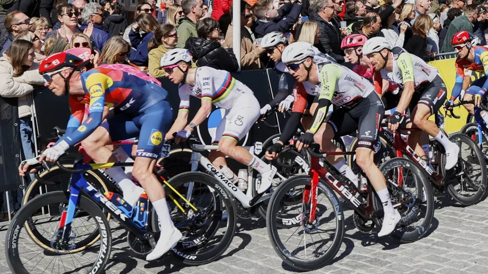 Slovenia's Tadej Pogacar, of the UAE Team Emirates XRG, second left, rides with the pack through the historical center of Oudenaarde, Belgium, during the Tour of Flanders on Sunday, April 6, 2025. (AP Photo/Geert Vanden Wijngaert)