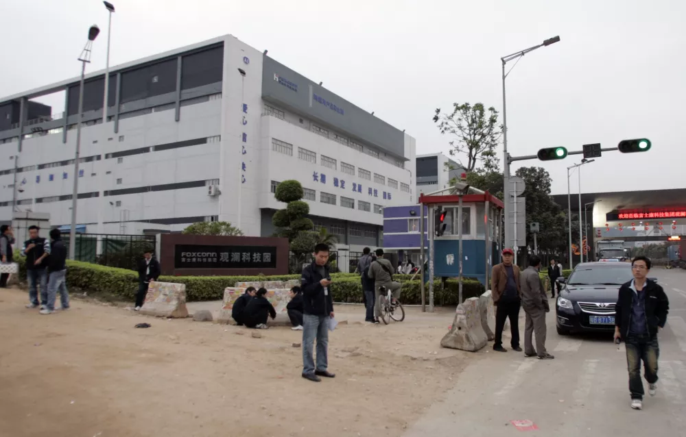 Workers walk outside Foxconn's factory complex in Guanlan in the southern Chinese province of Guangdong January 22, 2010. Foxconn manufactures products for Apple Inc. Picture taken January 22, 2010. To match special report APPLE-ASIA/SECRECY REUTERS/James Pomfret (CHINA - Tags: BUSINESS SCI TECH)