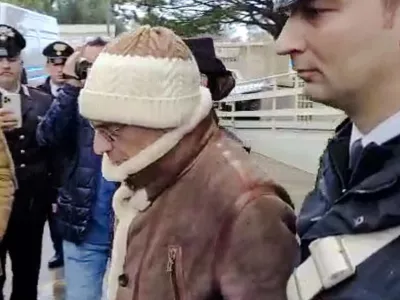 In this picture taken from a video released by Italian Carabinieri on Monday, Jan. 16, 2023, top Mafia boss Matteo Messina Denaro, center, leaves an Italian Carabinieri barrack soon after his arrest at a private clinic in Palermo, Sicily, after 30 years on the run, Monday, Jan. 16, 2023. (Carabinieri via AP)