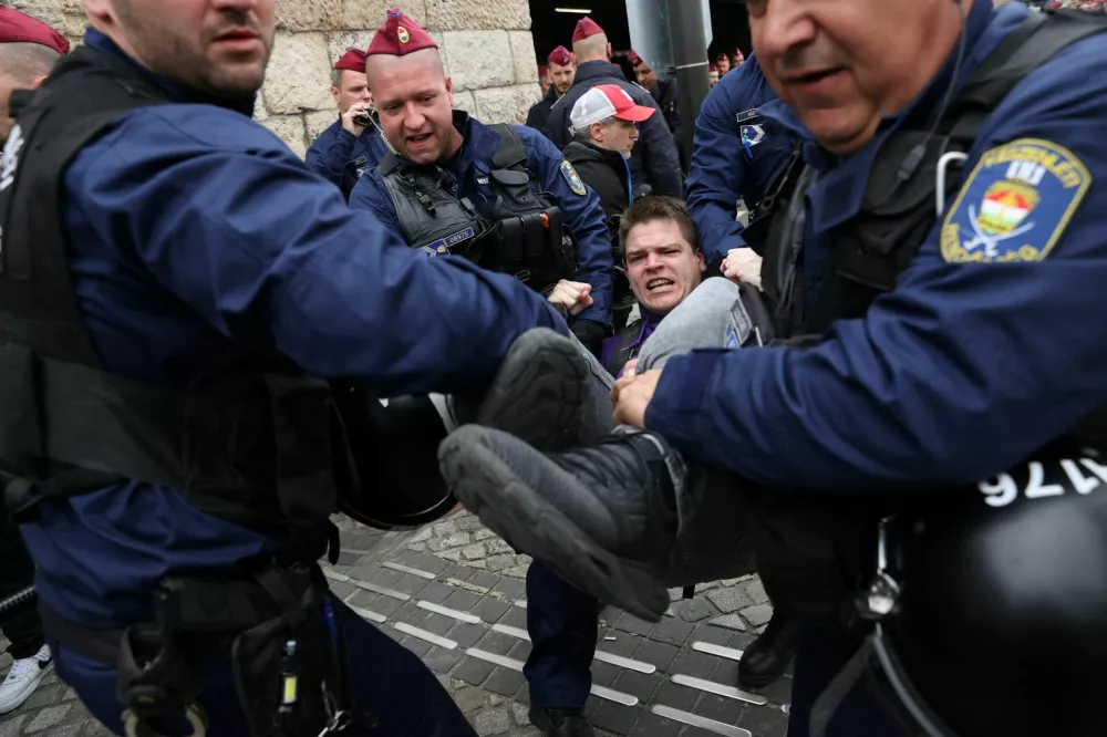 Police officers carry a protester as demonstrators block the entrance of the parliament's garage on the day the Hungarian parliament votes on constitutional amendments targeting the LGBTQ community, in Budapest, Hungary, April 14, 2025. REUTERS/Bernadett Szabo
