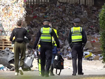 14 April 2025, Hamburg: Police officers are investigating the site of a recycling company where a dead man was found. Photo: Bodo Marks/dpa
